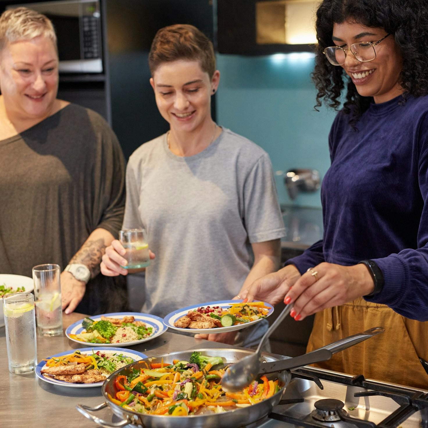 Community members collaborating in a contemporary kitchen, sharing recipes and cooking techniques